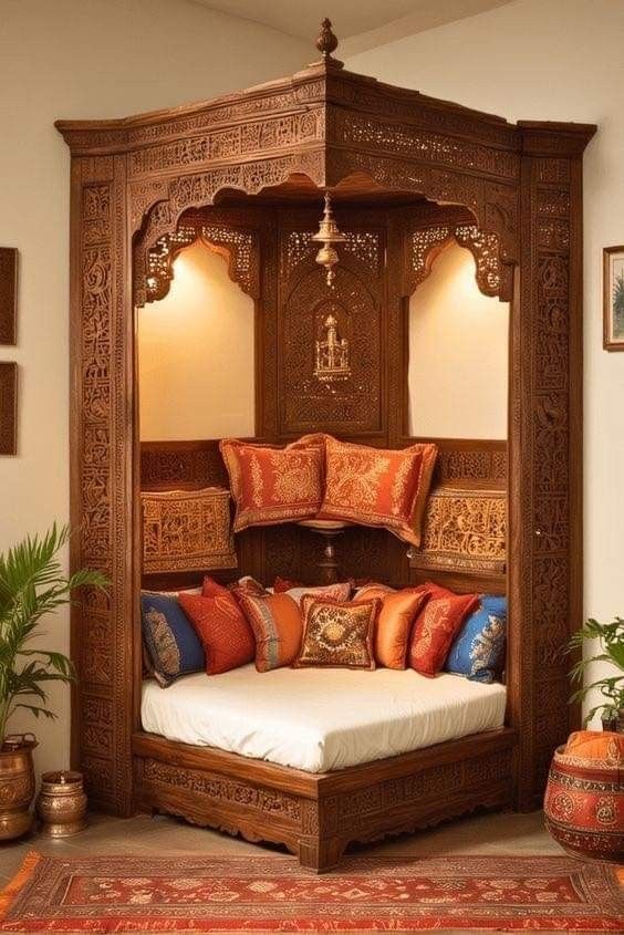 0eb55756-8477-484e-a1c6-7754e1b0864e Ornately carved wooden canopy seating nook with traditional Indian design, plush cushions, and ambient lighting.