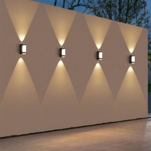 Row of modern up-and-down outdoor wall lights casting X-patterns.