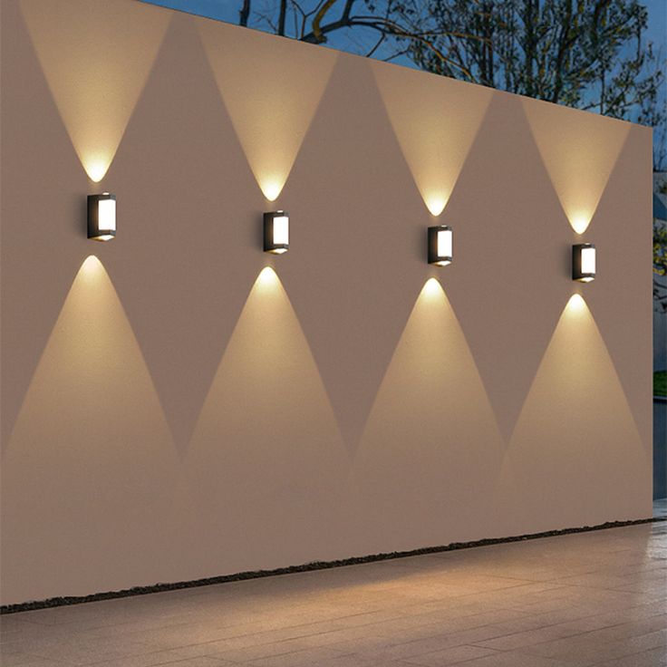 Orr Nordic Up Down Acrylic Outdoor Wall Lamp Row of modern up-and-down outdoor wall lights casting X-patterns.