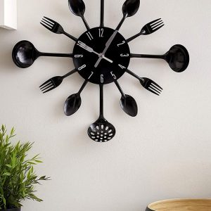 A unique black wall clock made from kitchen utensils such as forks, spoons, and ladles.