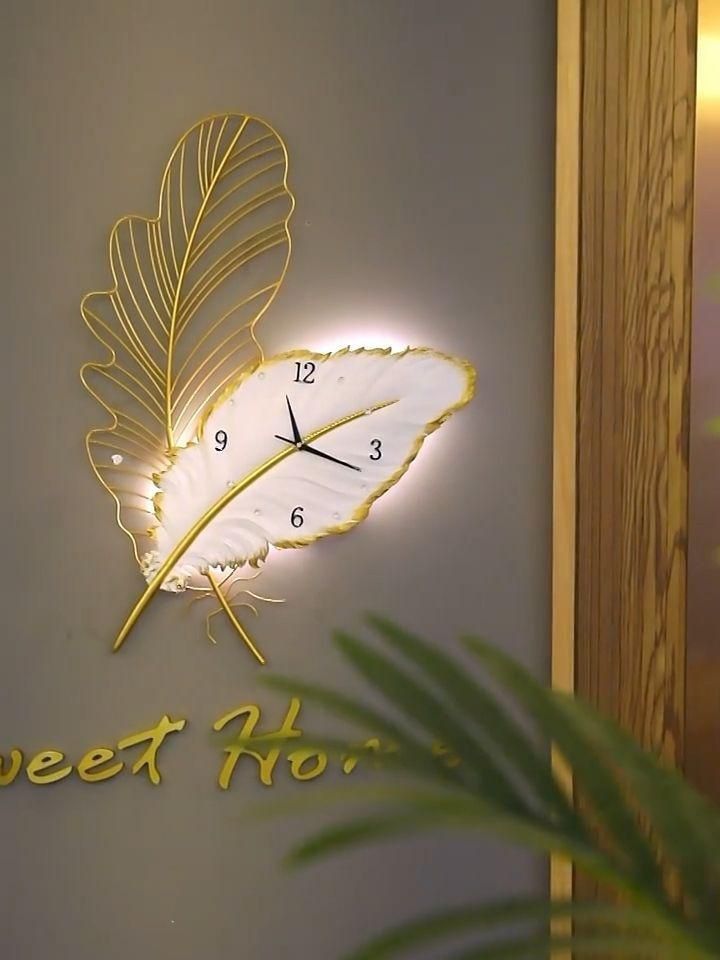 Gold & White Leaf-Inspired Designer Wall Clock A luxurious gold and white wall clock shaped like a leaf with built-in LED backlighting.